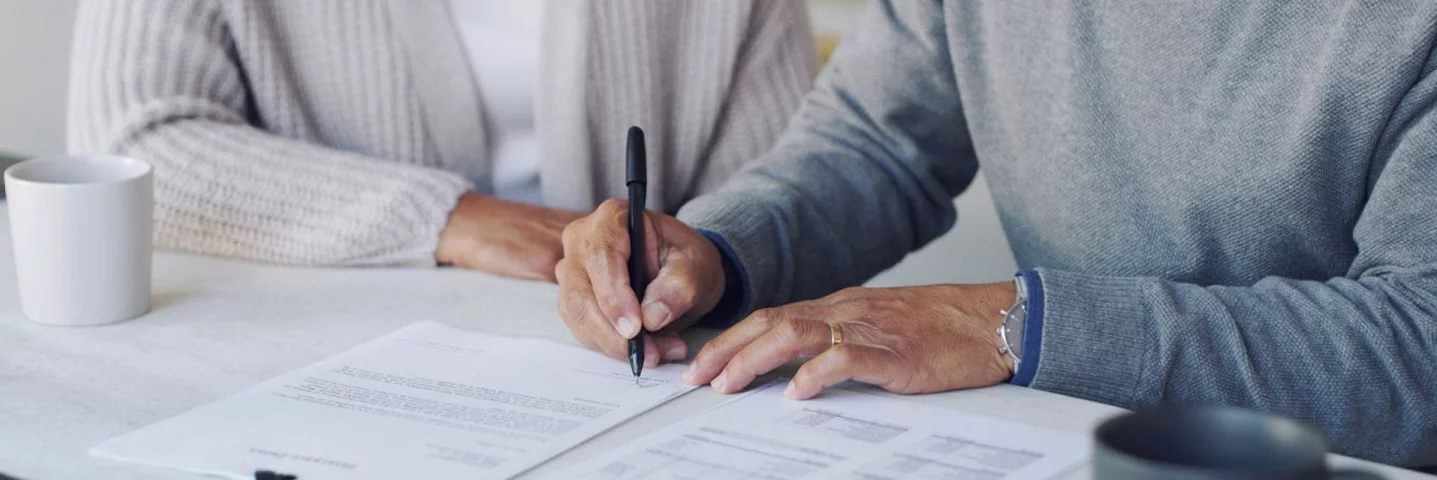Old man signing a document