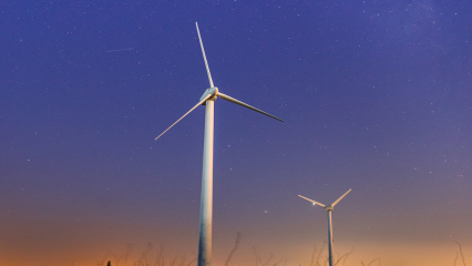 Two wind turbines in the night sky