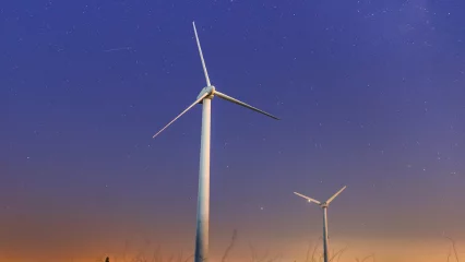 Two wind turbines in the night sky